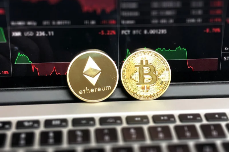 Two blockchain cryptocurrencies - Bitcoin and etherum on laptop