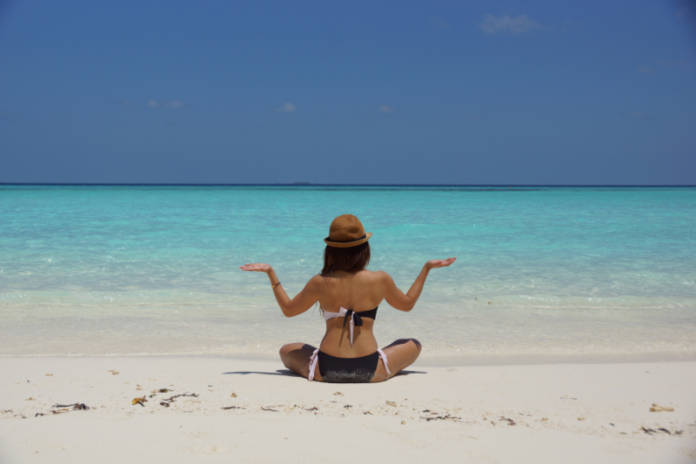 A girl is sitting on beach for vacation