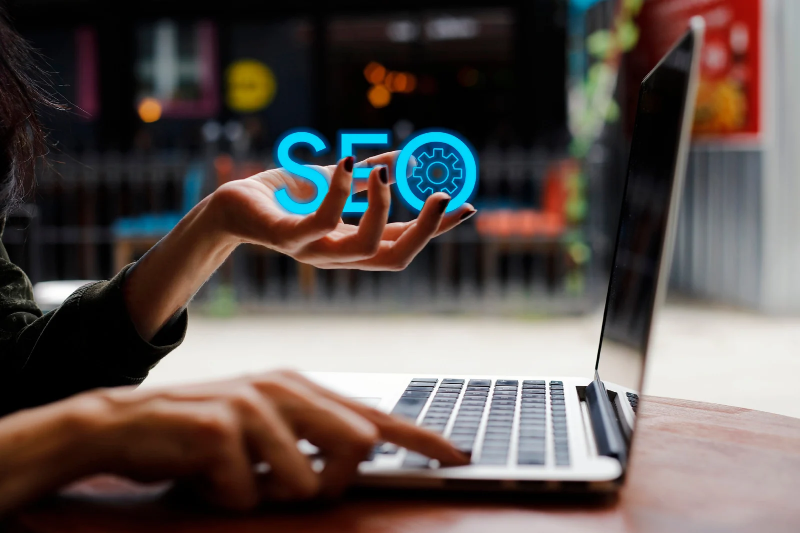 A lady is carrying seo logo on front of computer 