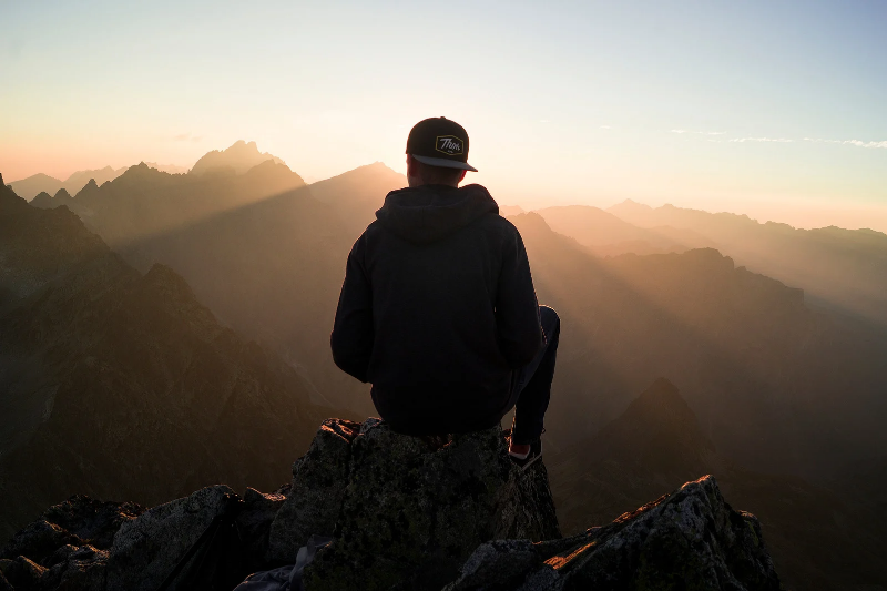 A man sitting over mountain to enjoy his life