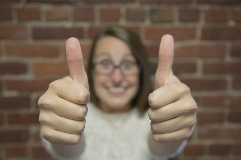 A girl is showing thums up as a gesture of good intentions 