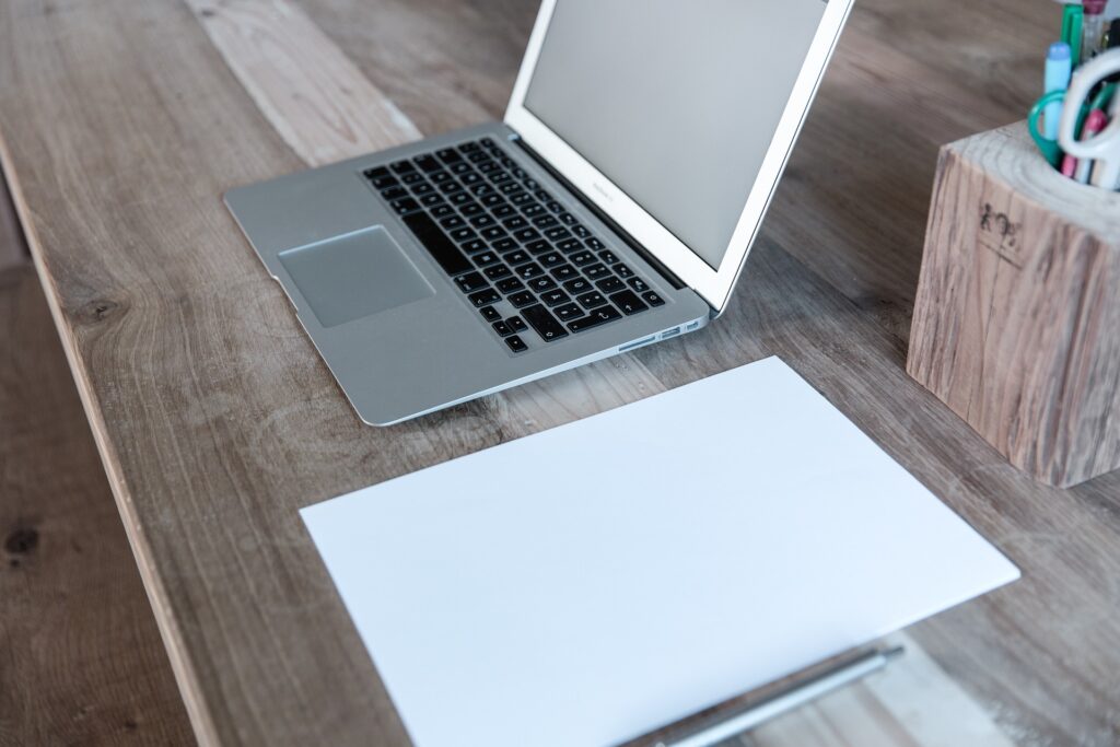 A laptop and copy is on table to write for us finance content 